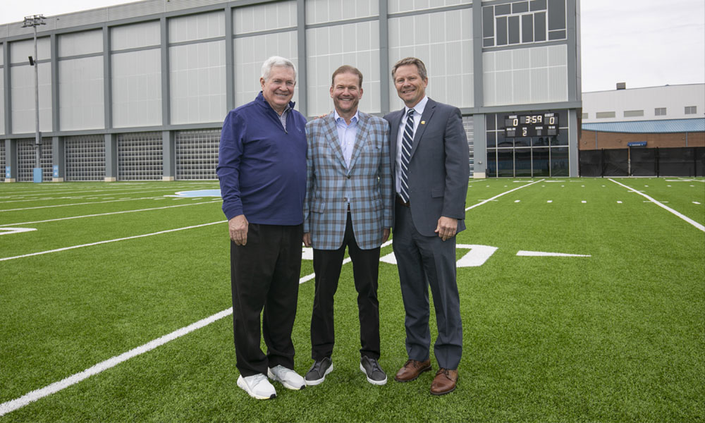 Bill Koman stands with head football coach Mac Brown and Chancellor Kevin Guskiewicz